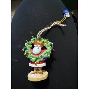 Cowboy Santa with‎ cactus wreath with lights.